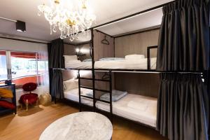 a bedroom with two bunk beds with a chandelier at Orange Lodge in Bangkok