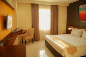 Postel nebo postele na pokoji v ubytování Noormans Hotel Semarang