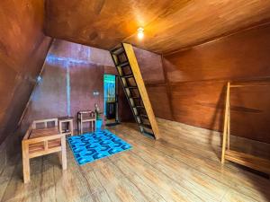 an attic room with a bunk bed and a table at Sanda Eco Cabins by AGATA in Padangan