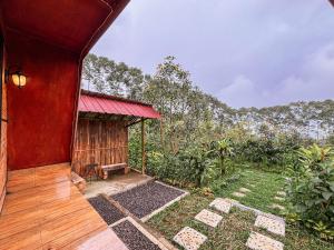 a house with a red roof with a view of a field at Sanda Eco Cabins by AGATA in Padangan