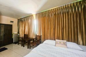 1 dormitorio con cama, escritorio y cortinas en Thai Gallery Baantawai, en Chiang Mai