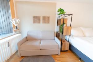 ein Wohnzimmer mit einem Stuhl und einem Bett in der Unterkunft Zentrales Apartment mit Balkon direkt am Wanderweg - Alpenperle Tegernsee in Tegernsee