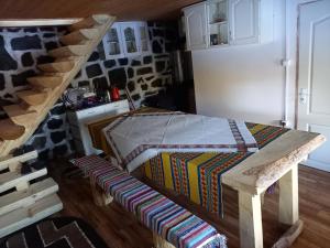 a room with a bed and a wooden table at Nyugalom Rönkhàz in Mureş-Sat