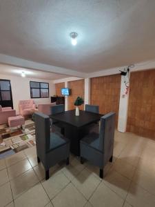 ein Esszimmer mit einem schwarzen Tisch und Stühlen in der Unterkunft Dpto Cómodo Barrio Guadalupe Céntrico con Estac y FREE WIFI in San Cristóbal de las Casas
