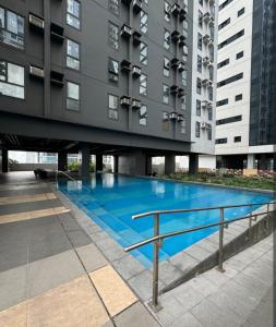 a large blue swimming pool in front of a building at Studio 7 Residential Building in Manila