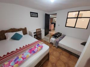 ein Schlafzimmer mit 2 Betten und einem Stuhl darin in der Unterkunft Dpto Cómodo Barrio Guadalupe Céntrico con Estac y FREE WIFI in San Cristóbal de las Casas