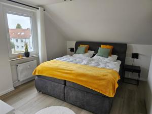 a bedroom with a large bed with a yellow blanket at Wohlfuehloase24 in Gütersloh