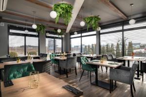 ein Restaurant mit Tischen und Stühlen und großen Fenstern in der Unterkunft Hotel Biancas in Kosakowo