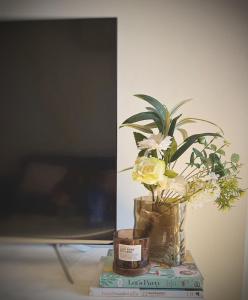 un jarrón con flores encima de un libro en RS703 - Serenity CBD View 1B with Balcony, Free Parking, VIC Market, Southern Cross, en Melbourne