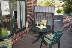 a patio with a table and chairs on a deck at Dat Kapitänshuus in Carolinensiel