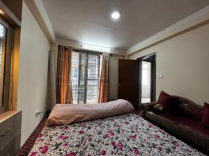 une chambre avec un lit, un canapé et une fenêtre dans l'établissement Bista Niwas, à Bhaktapur