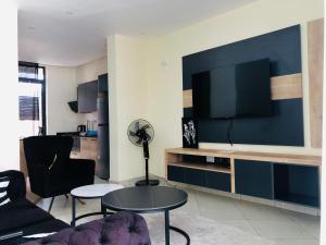 a living room with a tv and a couch and a table at AGASARO LUXURY Apartment in Kigali