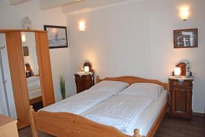 a bedroom with a bed with two night stands and a mirror at Dat Kapitänshuus in Carolinensiel