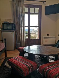 a living room with a table and a window at Πολύμνια in Agia Anna