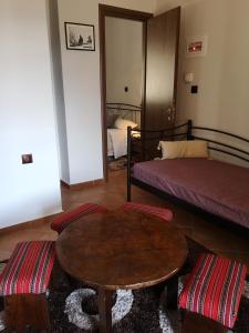 a room with two beds and a table and a bed at Πολύμνια in Agia Anna