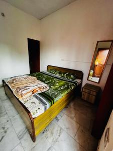 an empty bed in a room with a mirror at Madhuban Homestay, Natraj Chowk in Rishīkesh