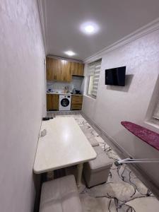 une petite cuisine avec une table dans une pièce dans l'établissement Rusmir Apartment, à Samarcande