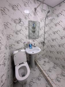 une salle de bain blanche avec toilettes et lavabo dans l'établissement Rusmir Apartment, à Samarcande