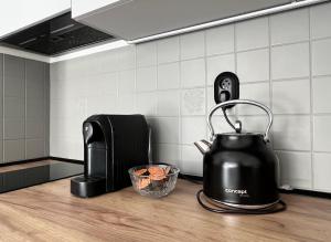 a black tea kettle on a counter in a kitchen at New cozy studio, AC & Balcony in Bratislava +25 photos