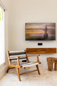 a room with a bench and a tv on a wall at Villa Dua Nomada in Kuta Lombok