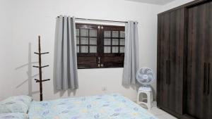 a bedroom with a bed and a window and a fan at Casa de campoWebers-Nova Cruz PE in Igarassu