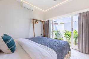 a bedroom with a bed and a large window at Villa Dua Nomada in Kuta Lombok