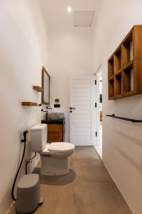a white bathroom with a toilet and a sink at Villa Dua Nomada in Kuta Lombok +20 photos