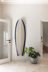 a mirror on a white wall with a potted plant at Villa Dua Nomada in Kuta Lombok