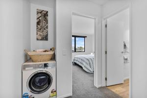 a washing machine in a room with a bedroom at Charming 2-Bedroom Townhouse in Christchurch
