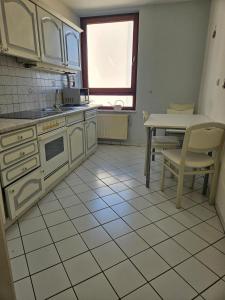 eine Küche mit weißen Geräten, einem Tisch und einem Fenster in der Unterkunft Bremens Herz Weser und Stadion in Bremen + 14 Fotos