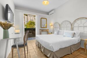 a bedroom with a bed and a desk and a chair at Hôtel La Villa Sainte Valérie Adults Only in Juan-les-Pins +37 photos