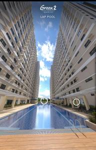 zwei hohe Gebäude mit einem großen Pool dazwischen in der Unterkunft Morena Suite,Staycation,WiFi,Netflix,Near DLSU & Malls in Dasmariñas