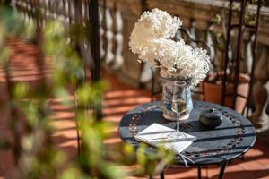 a table with a vase of white flowers on it at La Casa di Liszt - Luxury Suites in Florence