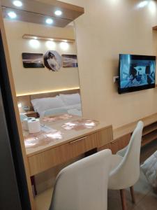 ein Zimmer mit Spiegel, Bett und Fernseher in der Unterkunft Morena Suite,Staycation,WiFi,Netflix,Near DLSU & Malls in Dasmariñas