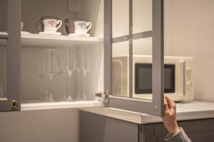 a person holding the door of a microwave in a kitchen at La Casa di Liszt - Luxury Suites in Florence