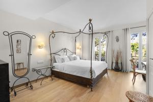 a bedroom with a canopy bed and a mirror at Hôtel La Villa Sainte Valérie Adults Only in Juan-les-Pins