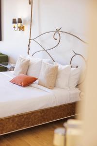 a bed with white pillows and a metal headboard at Hôtel La Villa Sainte Valérie Adults Only in Juan-les-Pins