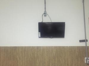 a flat screen tv hanging on a wall at Pousada Tilu in Aparecida