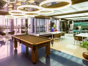 a pool table in a room with tables and chairs at ibis Styles Confins Aeroporto in Lagoa Santa