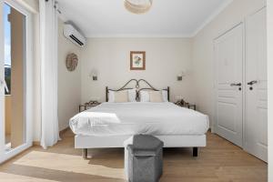 a white bedroom with a large bed with white sheets at Hôtel La Villa Sainte Valérie Adults Only in Juan-les-Pins