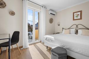 a bedroom with a bed and a desk and a window at Hôtel La Villa Sainte Valérie Adults Only in Juan-les-Pins
