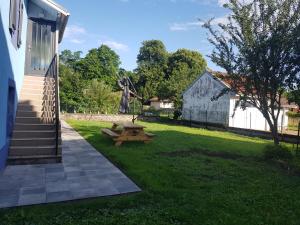 a picnic table in a yard next to a building at Joli petit studio les brimbelles in Granges-sur-Vologne