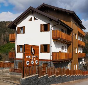 a building with wooden balconies on the side of it at Hotel Unik in Statiunea Borsa