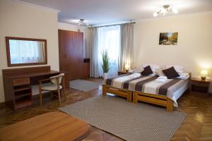 ein Schlafzimmer mit einem Bett und einem Schreibtisch und einem Schreibtisch in der Unterkunft DW Halicz in Solina