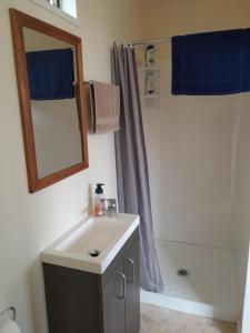a bathroom with a sink and a shower with a mirror at Sunset Accommodation in Westport