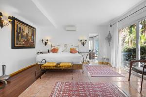 a bedroom with a bed and a large window at Hôtel La Villa Sainte Valérie Adults Only in Juan-les-Pins