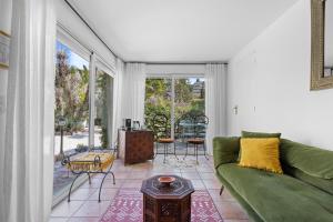 a living room with a green couch and a table at Hôtel La Villa Sainte Valérie Adults Only in Juan-les-Pins