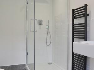 a shower with a glass door in a bathroom at Roundhill Cottages 1 in Grasmere +2 photos