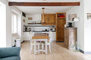 a kitchen with a table and chairs in a room at Le Valnotte - Proche plage et traversées iles in Barneville-Carteret +4 photos