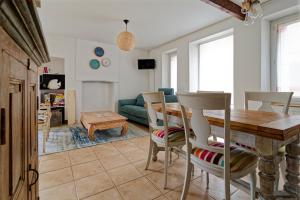 a kitchen and living room with a table and chairs at Le Valnotte - Proche plage et traversées iles in Barneville-Carteret